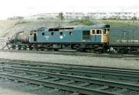 A sorry looking 27043 at Eastfield in June 1981. The locomotive (originally BRCW D5414) had been withdrawn in April 1980 following fire damage and was subsequently used for re-railing practice at the depot until disposal in November 1985. Disposal itself was unusual in that, after it was decided against conventional cutting up due to the presence of asbestos, the locomotive was eventually buried at <I>Paterson's Tip</I>, the large landfill site at Mount Vernon.  <br><br>[Colin Alexander 27/06/1981]