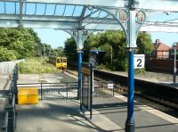 A St James bound Tyne and Wear Metro service leaves platform 2 at Whitley Bay station in July 2004 and heads south east towards Cullercoats. Note the canopy and scrollwork.<br><br>[John Furnevel 10/07/2004]