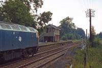 The former station at Mellis recorded on 20th August 1978 as 47115 dashes through with a Norwich to London service. The signal box was still in use despite the station (once the junction for the Eye branch) having closed to passengers some 12 years earlier. Note the signalmans <I>wing mirror</I>, enabling a better view of the level crossing and its signals. [Ref Query 15487]<br><br>[Mark Dufton 20/08/1978]