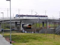 Tram westbound on the flyover at Edinburgh Park on 30 January 2014 as a Milngavie bound train passes beneath. <br><br>[Alasdair Taylor 30/01/2014]