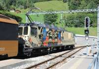 A colourful MOB metre gauge electric 6001 pauses at Les Avants with a northbound <I>Goldenpass</I> service from Montreux. On departure it will immediately enter a long tunnel. In the area between the cabs of these locos a sliding door gives access to a baggage/cycle holding area. The roof of the Sonloup Funicular lower station, accessible from the station platform, is just visible between the pantographs of 6001 [See image 45122]  <br><br>[Mark Bartlett 09/09/2013]