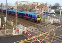 View north from the footbridge over Logans Road level crossing on the WCML just to the north of Motherwell station on 30 January 2014. The train is the 11.09 TransPennine Glasgow Central - Manchester Airport.<br><br>[John Furnevel 30/01/2014]