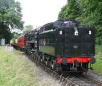 Immaculate looking BR Standard class 9F 2-10-0 no 92214 about to run tender first over the level crossing at New Bridge, Pickering, on 11 July 2012 with a train for Grosmont.<br><br>[John Furnevel 11/07/2012]