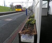 Green shoots beginning to appear at Neilston station on St Valentine's Day 2014. At the platform is the 12.00 service to Glasgow Central.<br><br>[John Yellowlees 14/02/2014]