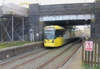 Tram 3055 departs Stretford for Altrincham, on the six minute interval service from Manchester. When used by MSJAR main line trains Stretford station had turnback sidings for extra Manchester departures, although nowadays there are just two through roads. The old street level booking office is still in use by a local newsagent.<br><br>[Mark Bartlett 13/02/2014]