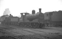 Most of withdrawn Aspinall ex-L&Y 0-6-0 no 52345 stands in the yard outside Bolton shed on an overcast day in mid 1963. Alongside on the right is WD Austerity 2-8-0 no 90267.<br><br>[K A Gray //1963]