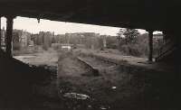 Looking out to the abandoned platforms of Kelvin Bridge station on 26 August 1974. Botanic Gardens behind the camera and the line to Stobcross ahead. The line crosses the River Kelvin here, the girder in the foreground being part of the bridge. Photograph by Tony Harden.<br><br>[Ewan Crawford Collection 26/08/1974]
