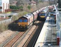 Longannet empties heading back to Hunterston rumble west through Alloa station on 11 March 2014 behind EWS liveried 66018. Standing at the platform is the 11.41 ScotRail service to Glasgow Queen Street, scheduled to follow 4 minutes later.<br><br>[John Furnevel 11/03/2014]