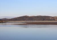 On a sunny spring evening a TransPennine 185 unit crosses the long viaduct over the Leven Estuary. The service is heading for Barrow-in-Furness, next stop Ulverston. This view taken from Canal Foot where the short Ulverston canal joined the estuary. <br><br>[Mark Bartlett 10/03/2014]