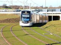 The green green grass of the South Gyle. An Edinburgh tram emerges from the tunnel under the A8 on a testing / familiarisation run on 11 March and slows as it approaches the tram stop at Gyle Centre. <br><br>[John Furnevel 11/03/2014]