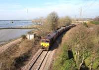 A Hunterston - Longannet coal train runs through the abandoned platforms of Kincardine station on 11 March, less than 2 miles from its destination. The train is about to pass below the 1936 Kincardine Bridge, much less busy these days thanks to the Clackmannanshire Bridge in the background, which opened in 2008. [See image 8861]<br><br>[John Furnevel 11/03/2014]