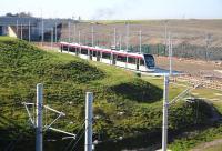 A tram stands on the concrete pad that will eventually become part of the Edinburgh Gateway tram stop. View north west on 11 March 2014 - the tram depot is on the other side of the bridge.<br><br>[John Furnevel 11/03/2014]