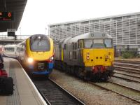 East Midlands Trains Meridian 222010 runs into Derby Station, a few minutes late, on 20 March 2014 with the 12.49 ex Sheffield to St Pancras service. Standing on the adjacent road are Devon & Cornwall Railways 56303 and 31452.<br><br>[David Pesterfield 20/03/2014]