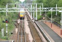 The north end of Bishopton station in April 2007, with a train leaving for Gourock. The overgrown line running off to the left accessed the former Royal Ordnance Factory. The 2,500 acre location, which employed 20,000 workers at its peak, had its own fleet of diesel locomotives operating over 20 miles of private track. Part of the huge abandoned site is currently earmarked for housing and other developments.<br><br>[John Furnevel 29/04/2007]