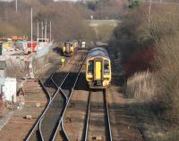 A Falkirk Grahamston - Glasgow Queen Street 158 approaching Cumbernauld in February 2005, seen from the station footbridge. The train has just passed a class 150 unit in the refuge siding which will eventually run back into the station's up platform to form the next service to Motherwell.<br><br>[John Furnevel 26/02/2005]