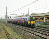 After several months of running in plain grey livery, First branding is starting to appear on the TPE Class 350s. 350405, passing Carnforth on a Manchester Airport to Glasgow Central service, is one of the first to receive the new vinyls.<br><br>[Mark Bartlett 09/04/2014]