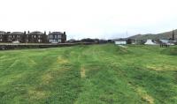 Looking east towards the main line at Girvan in April 2014 over the remains of the long-lifted sidings at the coal chutes. The formation of these can be easily traced even today. [See image 45090]<br><br>[Colin Miller 10/04/2014]