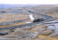 View over part of the enormous Jalainur Opencast Coal Mine, Inner Mongolia, with its own fleet of SY 2-8-2s, one of which is seen here in April 2000 with a local staff works train.<br><br>[Peter Todd 21/04/2000]