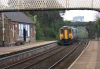 A Barrow to Carlisle service pulls away from the platform at Dalston in the early afternoon of 29 April 2014. Part of the large Nestle factory stands in the background beyond the road bridge.<br><br>[John McIntyre 29/04/2014]