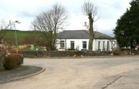 View north at the junction of the A7 and the B709 (left) in April 2014, showing the former Heriot station building, now a private residence. Opened in 1848 the building, which once incorporated the village post office, stood to the north of the level crossing opposite the staggered down platform. A signal box was located between the station building and the crossing itself with a small goods yard and cattle dock on the up side to the north. [See image 46103]<br><br>[John Furnevel 13/04/2014]