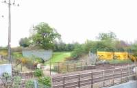 Looking east over the main line at Winchburgh on 1 May 2014, with the ruins of Niddry Castle beyond the trees. The brick bridge (now in the middle of a golf course) once carried a siding from the main line into the Niddry Castle shale oil refinery.<br><br>[Jim Peebles 01/05/2014]