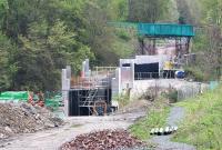 The northern approach to Galashiels on 3 May 2014. The new bridge over  Wheatlands Road is taking shape nearest the camera. Beyond that, work is in progress on the bridge spanning the Gala Water. In the background, bedecked in green sheeting, is the road bridge carrying Plumtreehall Brae over the trackbed. <br><br>[John Furnevel 03/05/2014]