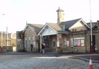 The station building at Shipley sits inside but at the south end of the triangle of lines. In this view across the forecourt the Bradford-Leeds/Ilkley platforms can be seen through the gap in the wall while the single Skipton platform is behind the camera. The much newer main line platforms [See image 40729] are directly opposite the station entrance but some distance away. <br><br>[Mark Bartlett 24/03/2014]