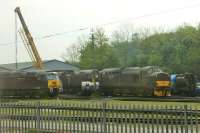 The West Coast Depot at Carnforth is not easy to see, except from passing trains on the Barrow line, hence this grab shot of the depot yard on 28 April. EE Type 3 37706 is idling on one of the depot roads, alongside two Brush Type 4s, one of which appears to be undergoing an engine or generator transplant. In addition to two Class 08 yard shunters, WCRC maintains an operational fleet of around twenty main line diesels of Classes 33, 37, 47 and 57. <br><br>[Mark Bartlett 28/04/2014]