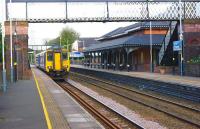 A Manchester bound service passes Rainhill non-stop on 19 April 2014. The Grade 2 listed station building is still in use as a ticket office and waiting room, having undergone a major restoration in 2010/2011. With work on the electrification of the line underway at present the view may well change significantly in the coming months. <br><br>[John McIntyre 19/04/2014]