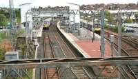 Looking east over Airdrie station on 8 May 2014. The 09.57 Milngavie - Edinburgh Waverley has just arrived at platform 3, while the 10.56 service to Balloch is awaiting its departure time in bay platform 1. [See image 50194]<br><br>[John Furnevel 08/05/2014]