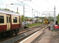 After leaving the refuge siding at the north end of Cumbernauld station, 158869 runs back into platform 1 where it will form the 11.28 service to Glasgow Queen Street. Waiting at platform 2 on the left ready to take its place in the siding is 318252, recently arrived from Springburn [see image 47266].<br><br>[John Furnevel 08/05/2014]