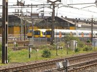 London Overground Class 378s stabled alongside Willesden depot on 10 May 2014 seen from a passing train. The locomotive standing beyond the EMUs appears to be 86101.<br><br>[John McIntyre 10/05/2014]