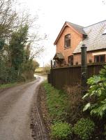 Although track and gates have gone, one set of gate posts remains on the west side of the level crossing at Longdon Road on 4 March 2014. The station was to the left and the goods yard to the right. The former railway house has been extended across the trackbed. [See image 46801]<br><br>[John McIntyre 04/03/2014]