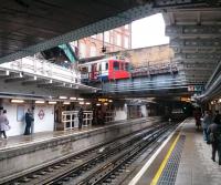 View from the low-level (East London Line) platforms at Whitechapel on 27 May as an Eastbound District Line train leaves the high level station for Upminster. There were formerly four District Line tracks spanning the ELL here but the centre pair have been removed to make space for Crossrail works.<br><br>[John Thorn 27/05/2014]