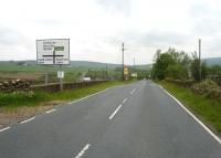 The bridge parapets alongside the Holmfirth to Penistone road cross the former Hepworth Iron Co branch that once left the Woodhead route at Hazlehead Bridge. View east on 30 May 2014. [See image 47490]<br><br>[David Pesterfield 30/05/2014]