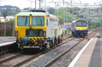 Tamper DR73933 waits for the road at Cumbernauld on 30 May as 320321 crosses over from the turnback siding.<br><br>[Bill Roberton 30/05/2014]