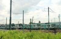 Grab shot showing several lines of withdrawn T68 trams at Old Trafford Metrolink depot in June 2014, seen from a tram on the East Didsbury line. The last T68 run was a special two weeks previously and, whilst set 1007 will be preserved on the Heaton Park Tramway, C F Booths have already started cutting up others. <br><br>[Mark Bartlett 09/06/2014]