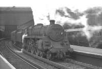 A BR Standard class 4 4-6-0, doing its best to conceal its identity, waits with a train at Waterloo station around 1965.<br><br>[K A Gray //1965]