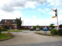 The Sidings Hotel & Restaurant at Beningbrough and two of the three grounded Mark One accommodation carriages seen through the site entrance on 29 June, with a semaphore signal standing guard by the roadside. A further two parallel carriages are out of view to the left, with one a first class layout dining carriage to supplement the dining area of the main building. Both have a clear view of activity on the East Coast Main Line which runs on the far side of the building. [See image 21805]<br><br>[David Pesterfield 29/06/2014]