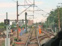 The temporary single line working through Victoria operates on a sort of staff, ticket and pilotman arrangement whereby two or three trams travel in the same direction before running is reversed. A narrow control cabin has been built between the tram tracks at the <I>Platting Bank</I> end of the section, seen here over the driver's shoulder of a Bury bound tram. <br><br>[Mark Bartlett 09/06/2014]