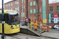 Single line working in action. The pilotman, arriving at Shudehill on the last tram through the Victoria station single line section, uses the token/key to unlock and swing back this <I>STOP</I> barrier that was across the northbound track. 3057 will proceed towards Rochdale, and the pilot will follow on a Bury service, closing and locking the barrier behind the tram. At the north end of Victoria, where the track doubles again [see image 47863], the process will start again. <br><br>[Mark Bartlett 09/06/2014]