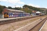 Stalybridge station underwent a transformation in 2012 and now has five platforms. On 5 July 2014 a terminated Northern service from Wigan is waiting at platform 5 to return as far as Manchester Victoria. In Platform 4 TransPennine 185143 is about to continue its journey to Leeds. Thanks to Adrian Morgan for the correction on the year that the alterations to the station took place.<br><br>[John McIntyre 05/07/2014]