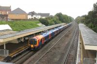 The covered footbridge (with open sides) at Pokesdown provides a good vantage point on a wet day. Evidently the station once had more tracks than the two that now suffice. Most SWT services in the Bournemouth area are handled by 444 EMUs but the Class 450 suburban sets make appearances on stopping trains. 450561 is on the rear of a westbound eight car set making its last call before Bournemouth.<br><br>[Mark Bartlett 23/05/2014]