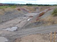 View from the new A6106 bridge over the Borders Railway south of Shawfair station between Newton and Millerhill villages, on 14 July looking south to the old road embankment, soon to be breached.<br><br>[Bill Roberton 14/07/2014]