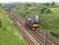 West Coast Railway 37516 heads north on the WCML at Kirtlebridge on 1 June 2014 over the emergency crossovers running light engine Carnforth to Craigentinny. The bridge in the background carries the B7076 (formerly the A74 trunk road) over the railway while beyond that the A74M crosses the railway. Between the two was Kirtlebridge station and the connection with the Solway Junction Railway [ref query 8112]. [See image 28903]<br><br>[John McIntyre 01/06/2014]