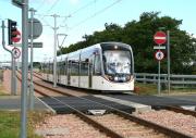 A city bound Edinburgh tram about to pass over an internal airport level crossing shortly after leaving the terminus on 13 July. A second recently arrived tram stands at the platform in the left background. <br><br>[John Furnevel 13/07/2014]