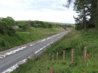 The future double-track solum of the Fushiebridge-Tynehead dynamic loop, looking south at Tynehead station on 15th July. Note the route of the former siding to the east of the line, now used as an access road for contractors, and in the foreground the concrete uprights of the former path to the Down platform (with thanks to Colin Maclean).<br><br>[David Spaven 15/07/2014]