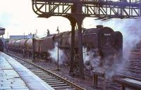 BR Standard class 9F 2-10-0 no 92019 takes on water in the up loop at Carstairs station on 24 July 1964 with a southbound freight.<br><br>[John Robin 24/07/1964]