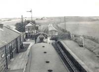 View north from the footbridge at Newmachar station on 15 August 1960 as B1 4-6-0 no 61352 waits at the platform with empty stock for storage on the stub of the Boddam branch. The train is about to cross an Aberdeen bound DMU. [Additional info from notes taken by JR - one of the group sitting on the left]<br><br>[G H Robin collection by courtesy of the Mitchell Library, Glasgow 15/08/1960]
