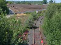 Looking north along the former south/east chord at the south end of Millerhill Yard on 22 July 2014. Coaching stock stands alongside the wagon repair shop top right, while groundwork is underway elsewhere. Part of the area once occupied by the down yard is earmarked to house a recycling centre for food and residual waste, with a new EGIP electric train servicing facility to be constructed on the up side. [See image 48305]<br><br>[Bill Roberton 22/07/2014]